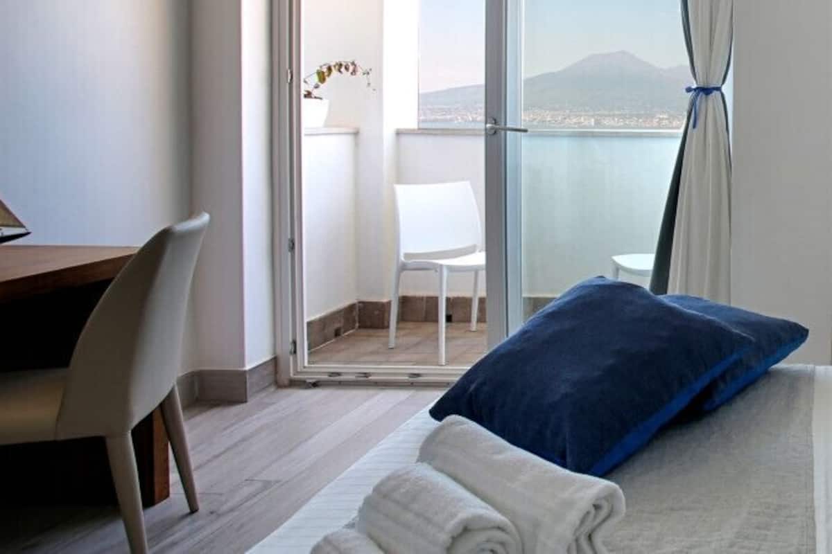 Una habitación de hotel con cama, escritorio y vistas al exterior.
