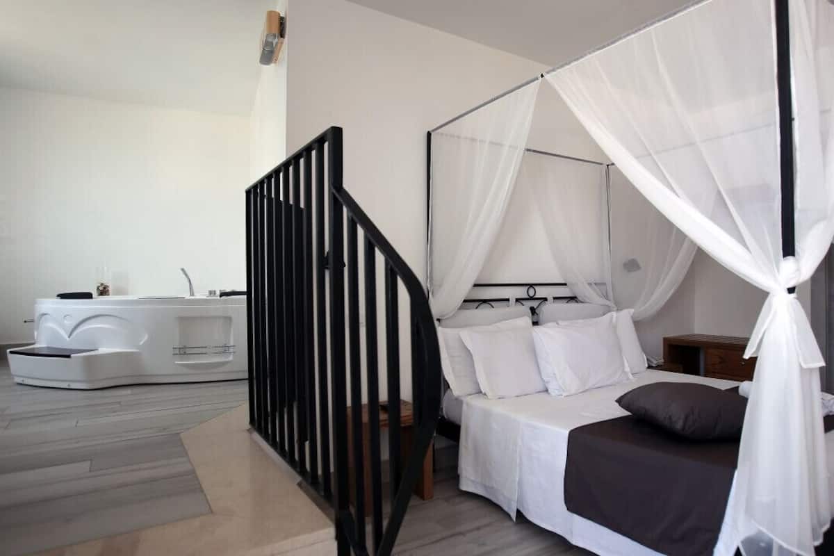Un dormitorio moderno con una cama con dosel, una mesita de noche blanca y un pequeño mueble de noche de madera.