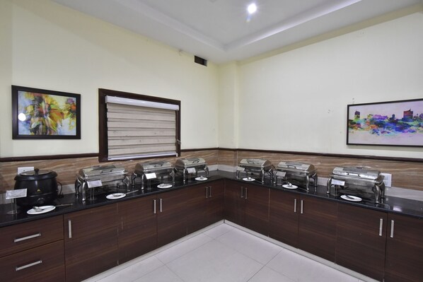 A kitchen with a dark brown countertop, stainless steel appliances, and a white tiled floor. - Hotel New Palace (Dalhousie)