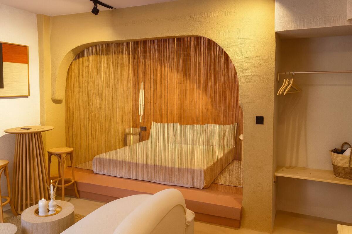 A bedroom with a bed, a small table, and a chair.