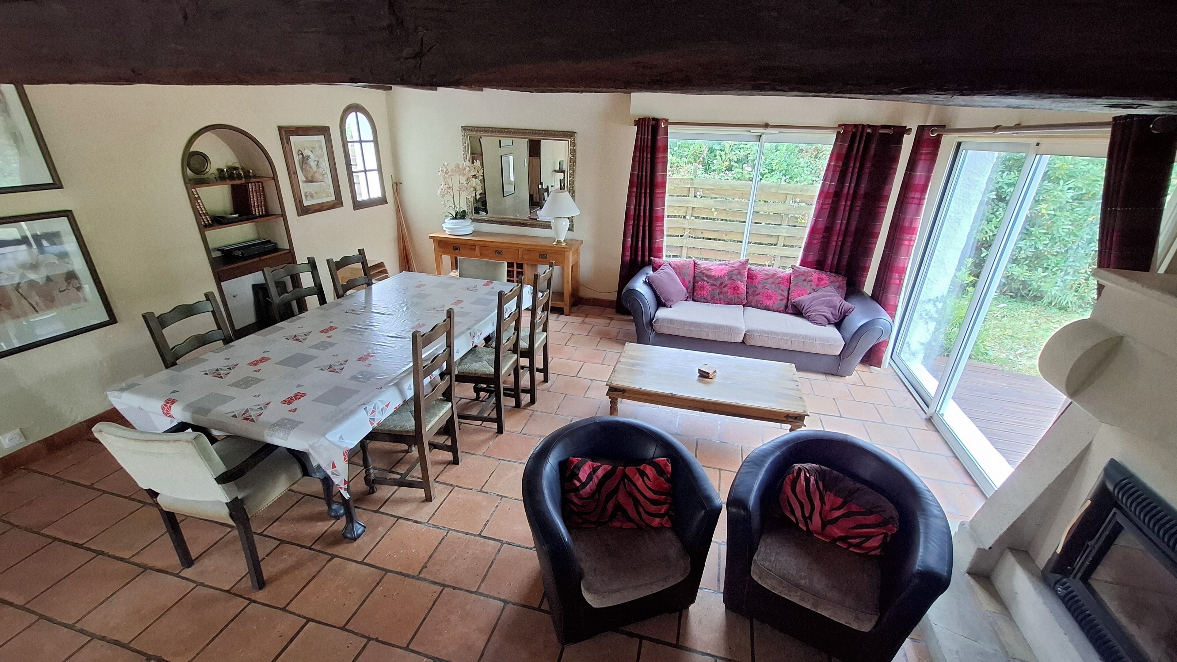 Un coin repas avec une table et des chaises, un canapé et une cheminée.