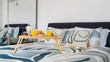 Ein Bett mit einem Tablett mit Frühstücksartikeln, darunter Croissants, Kaffee und Orangensaft.