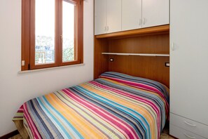 A bedroom with a bed, a window, and a wardrobe.