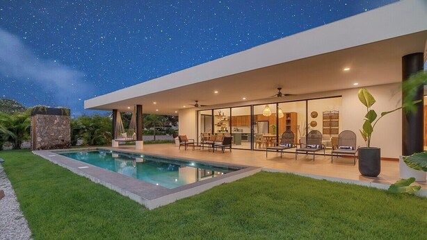 A modern house with a swimming pool, outdoor seating, and a starry night sky. - Casa Curime (Los Almendros, Hacienda Pinilla)