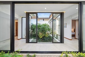 Un interior moderno con un puerta de cristal que da a un jardín.