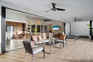 A spacious living area with a modern design, featuring a sofa set, coffee table, and chairs.