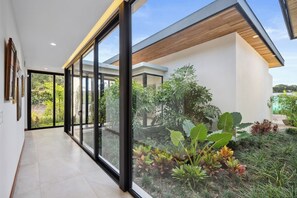 A modern interior with a glass door leading to a garden.