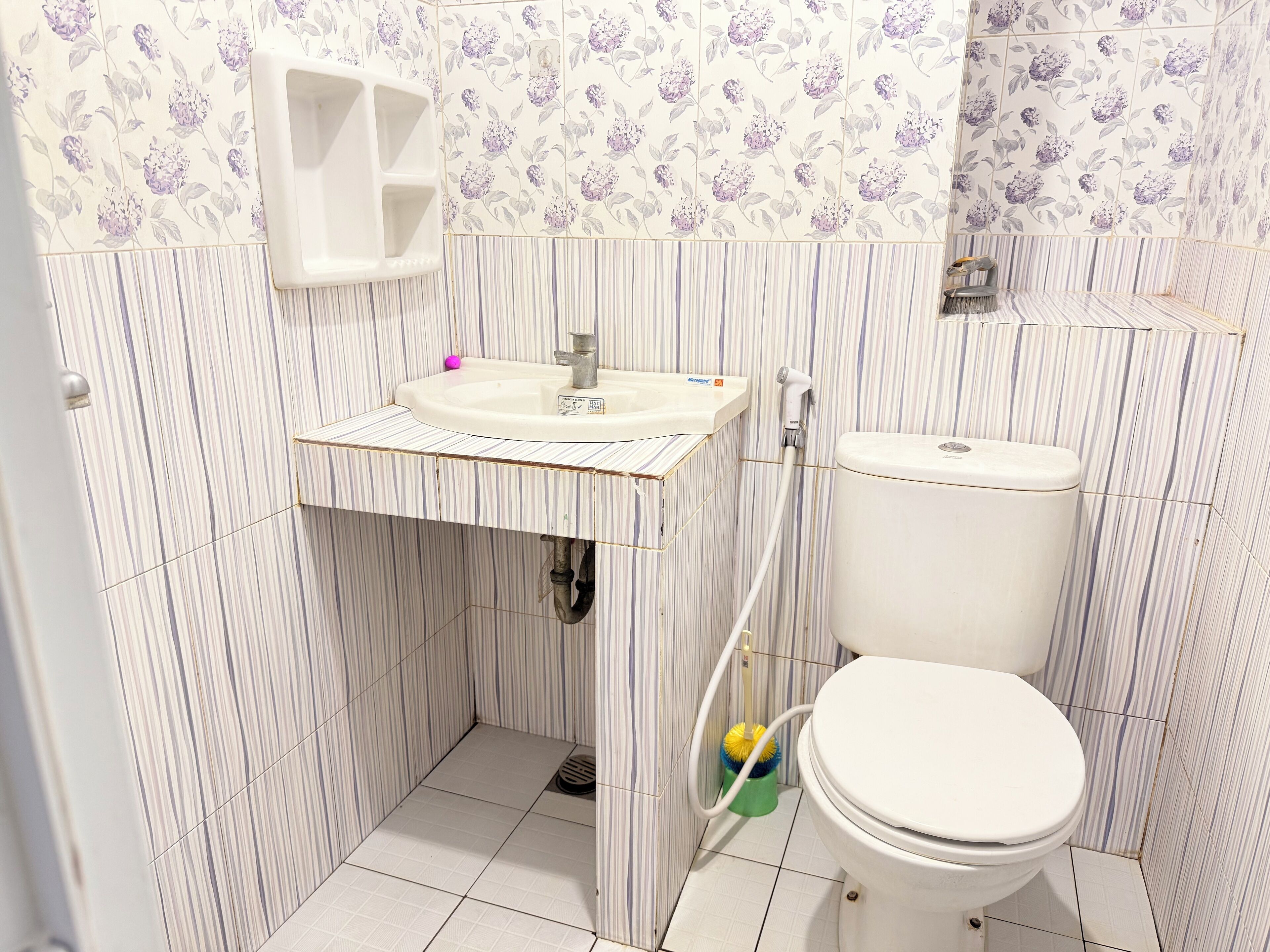 A small bathroom with a toilet, sink, and shower.