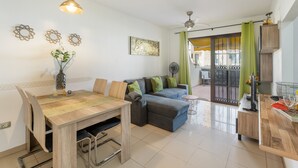 Una sala moderna con una mesa de comedor, sofá y vistas a través de un ventanal.