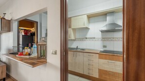 Una cocina con armarios de madera, extractor de acero inoxidable y una encimera con diversos objetos.