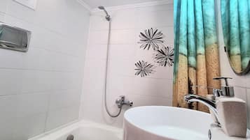 Une salle de bain avec une baignoire, des toilettes et un lavabo.