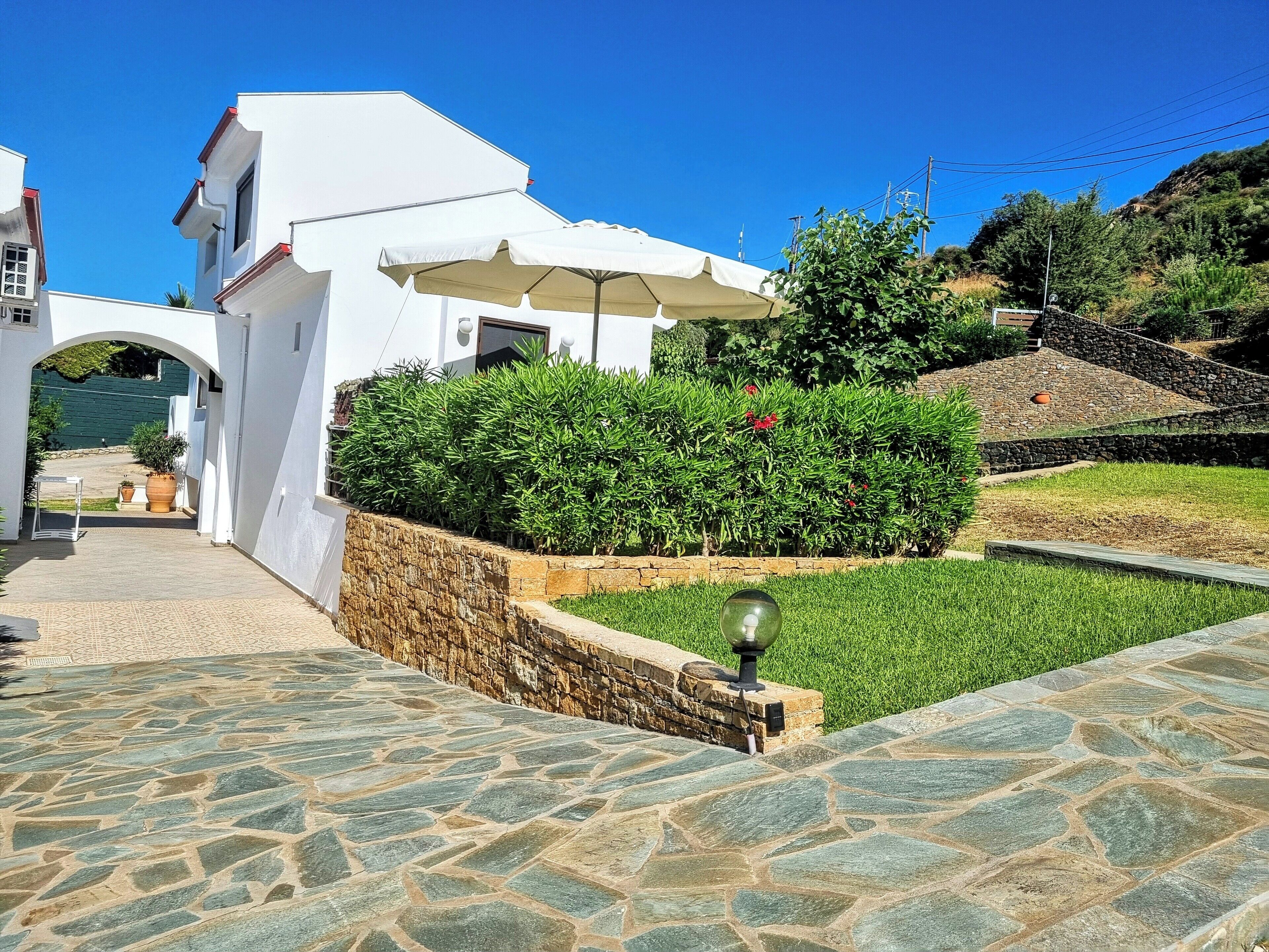 A white building with a stone pathway leading to an entrance.