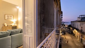 Un balcon donnant sur une rue au crépuscule.