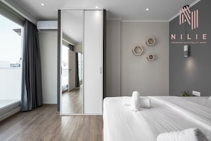 Una habitación de hotel moderna con una cama grande, una puerta corredera y vistas a la ciudad.