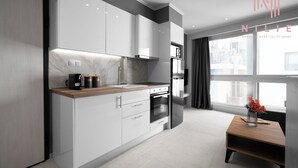 A modern kitchen with white cabinets, a wooden countertop, and a built-in oven. - Bonsai Studios & Apartments, Nilie Hospitality MGMT (Thessaloniki)