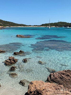 A clear coastal area with rocky formations and calm waters.
