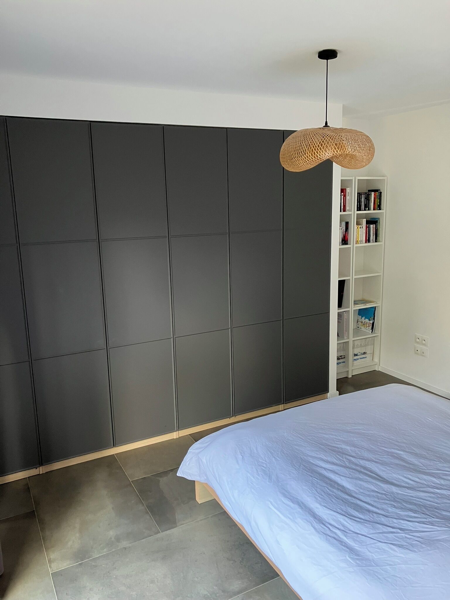 Une chambre à coucher avec un lit, une armoire et une bibliothèque.