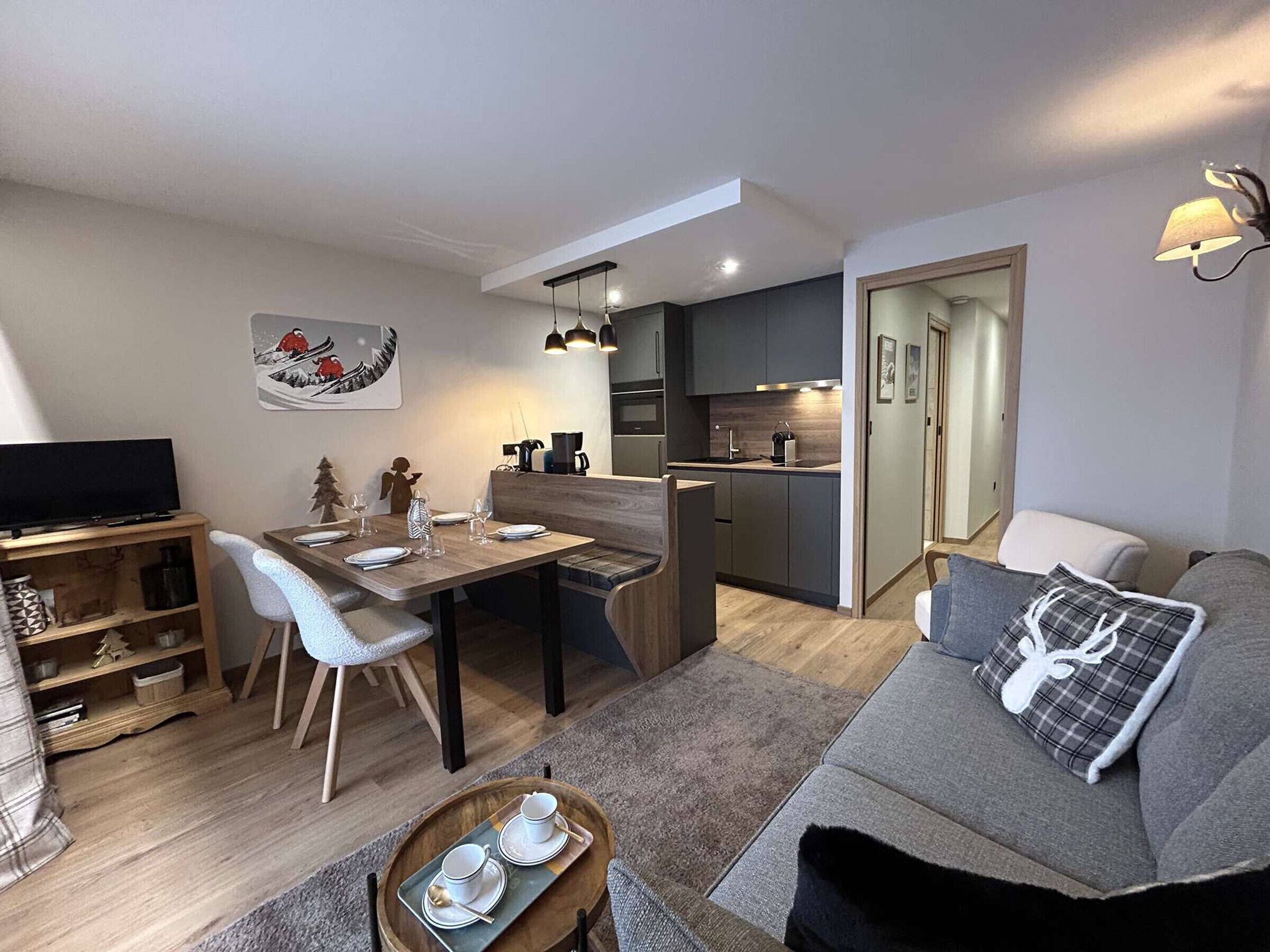 Eine moderne Wohnung mit Essbereich, Küche, Wohnzimmer und Fernseher.