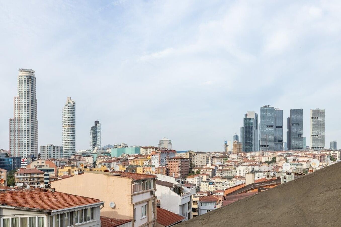 Un paysage urbain mêlant des immeubles modernes de grande hauteur à des bâtiments traditionnels de faible hauteur.
