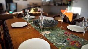 Une table à manger dressée avec des verres, des assiettes et un set de table décoratif.