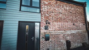 Un bâtiment à deux étages, doté d’une façade en briques et d’une porte de couleur foncée.