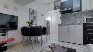 Eine moderne Küche mit Mikrowelle, Kühlschrank und Essbereich mit Tisch und Stühlen.
