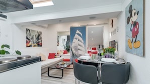 Eine moderne Küche mit Essbereich, ausgestattet mit einem großen Fenster, einem Esstisch für vier Personen und einer Kücheninsel.