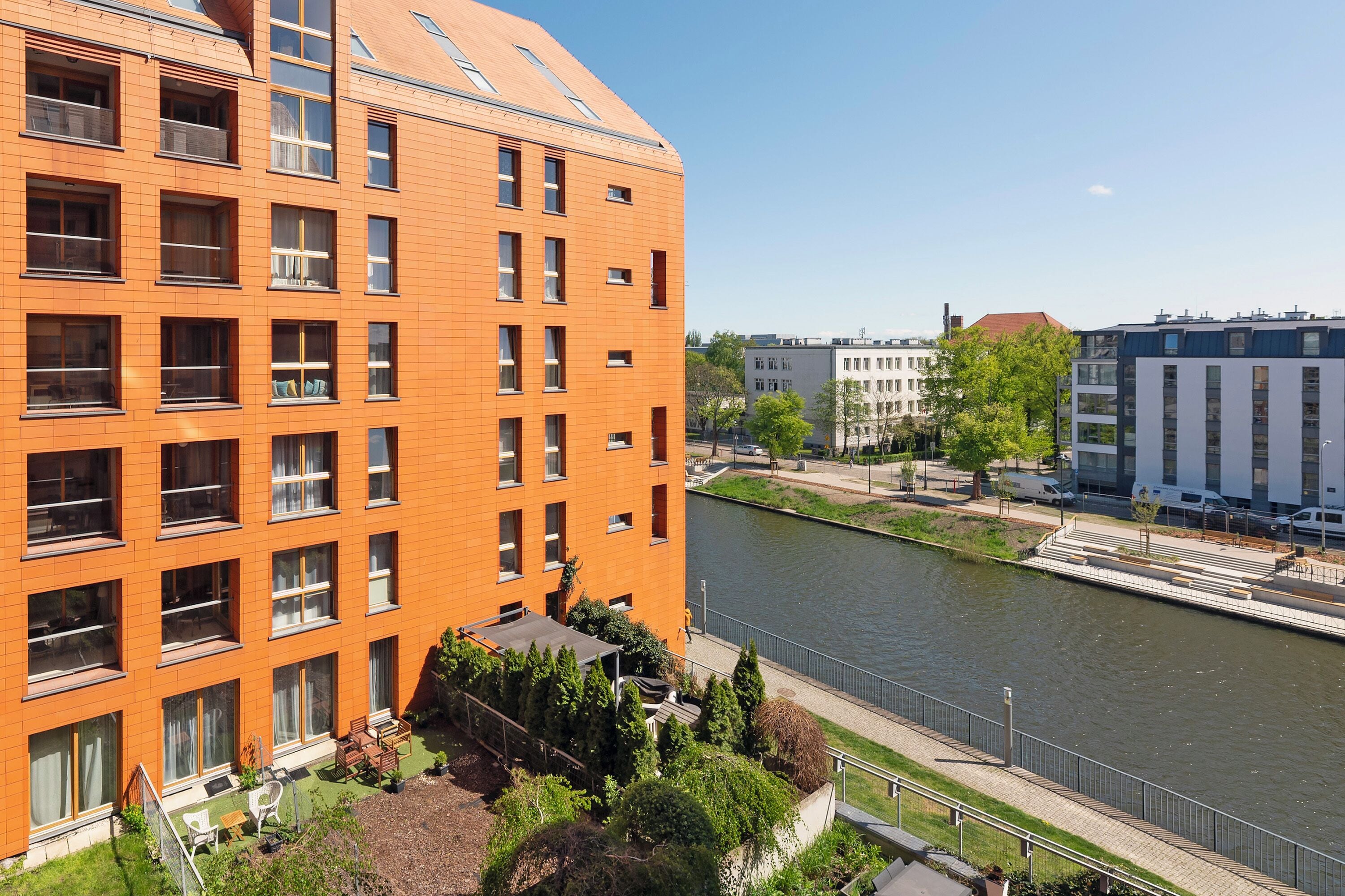Un immeuble à plusieurs étages avec une rivière en arrière-plan.