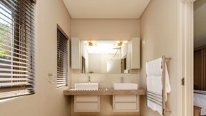 A modern bathroom with two sinks, a large mirror, and a towel rack. - Cliff Break (Knysna)