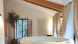 A modern spa room with a wooden hot tub, a wooden bench, and a large window with a view of trees. - La Cabane Du Trappeur   Lyon Country House (Caluire et Cuire)
