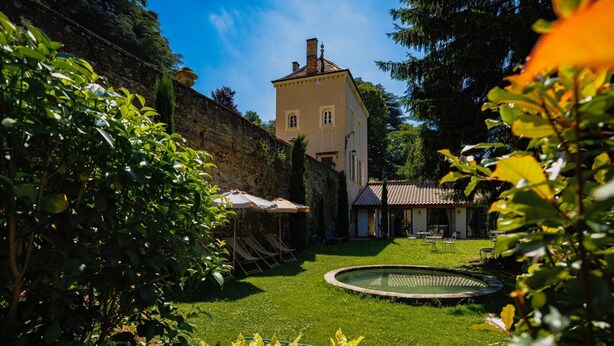 A well-maintained garden with a fountain, a pool, and a building with a tiled roof. - La Cabane Du Trappeur   Lyon Country House (Caluire et Cuire)