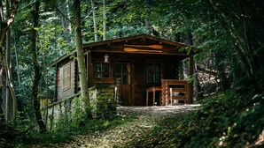A rustic cabin with a wooden exterior, a porch, and a bench. - La Cabane Du Trappeur   Lyon Country House (Caluire et Cuire)