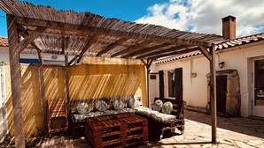 A courtyard with a wooden bench, a wooden table, and a stone floor. - House near the sea!  (Grues)