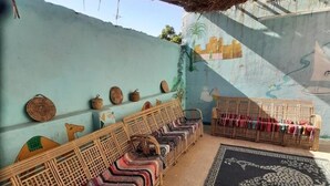 Una habitación con techo bajo, alfombra estampada y una pared con un mural.