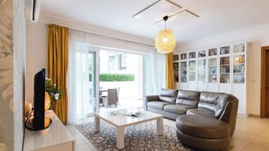 A modern living room with a leather sofa, a coffee table, and a bookshelf. - 102 Seafront 3Bed Sliema with pool by Homely (Tas-Sliema)