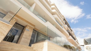 Un hotel moderno con varios balcones, fachada de vidrio y un cartel que indica 'Town's End Block D'.