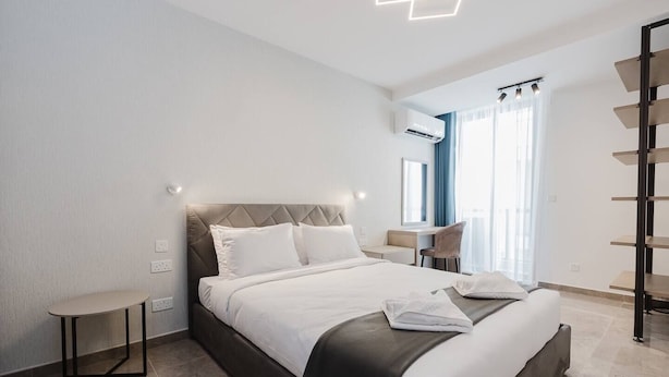 Una habitación de hotel moderna con una cama grande, un escritorio y una silla.