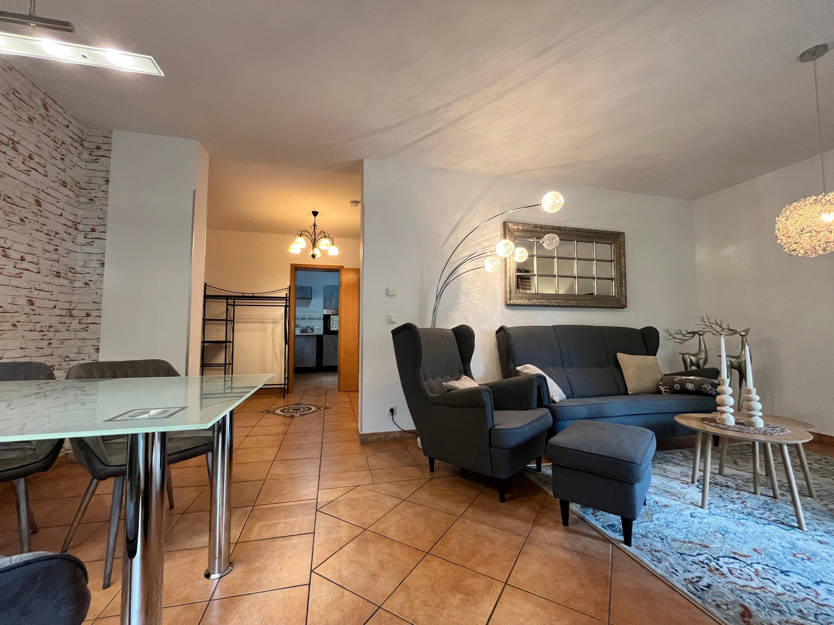 Una sala moderna con una mesa de comedor de vidrio, un sofá y una mesa de centro.