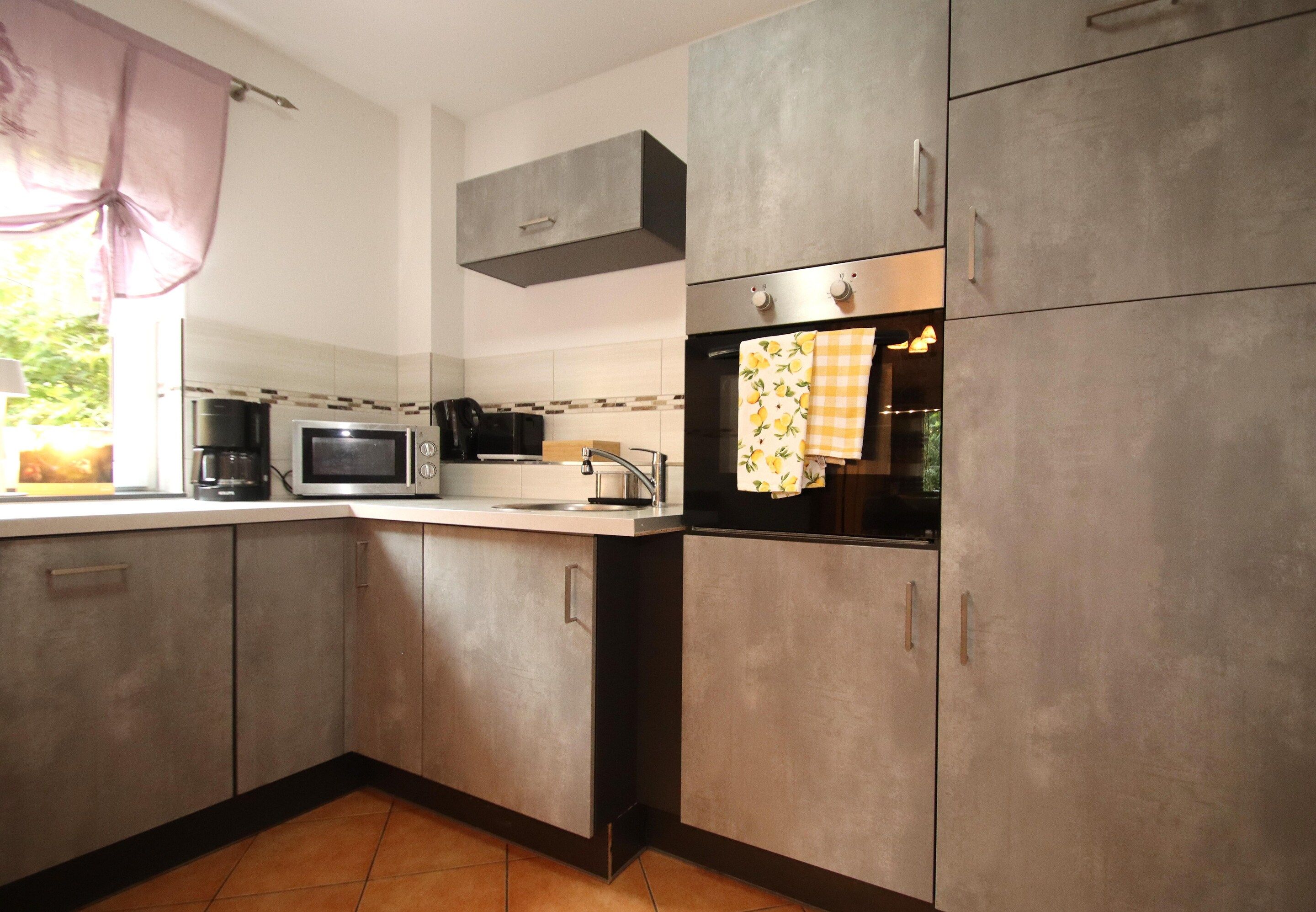 A kitchen with a microwave, oven, and cabinets.