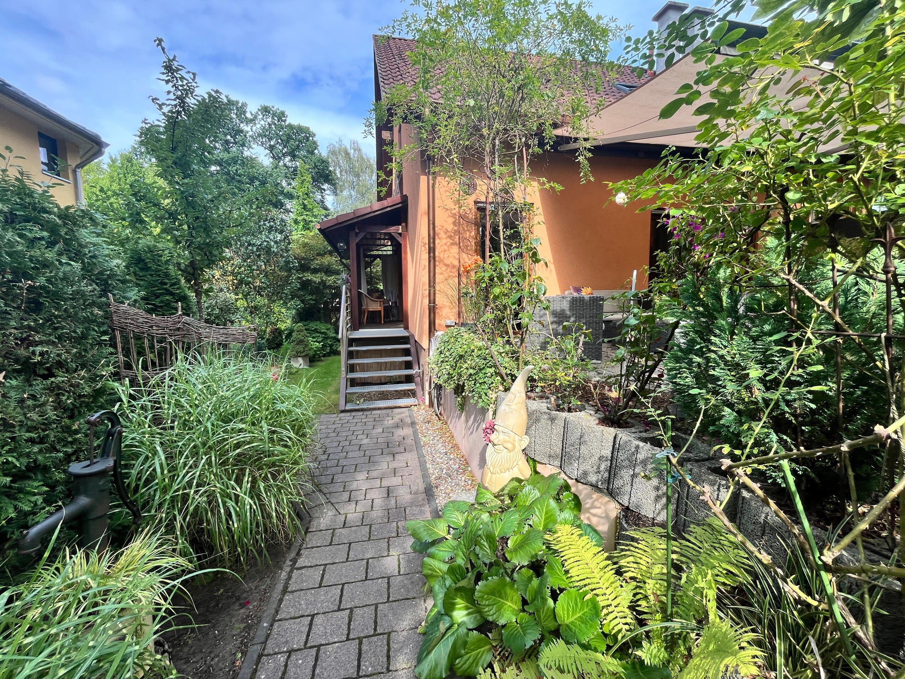 A garden pathway leading to a wooden structure with a staircase.