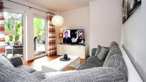 En moderne stue med sofa, sofabord og fjernsyn.