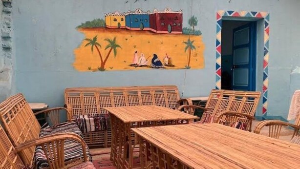 Un espace repas avec des meubles en bois et une fresque murale.