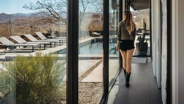 Un intérieur moderne avec de grandes portes vitrées donnant accès à un espace piscine extérieur.