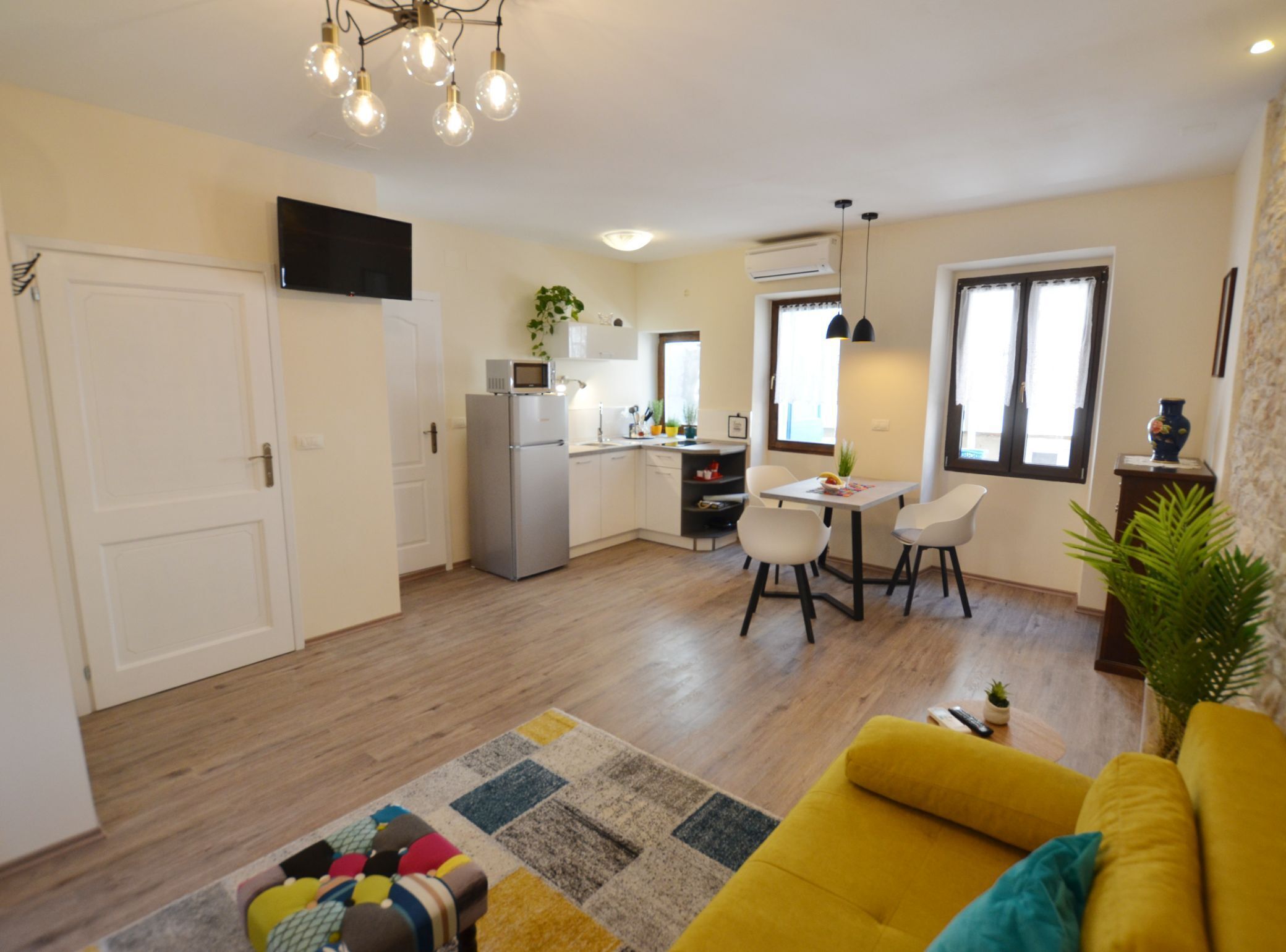 A modern apartment with a kitchen, dining area, and living room.