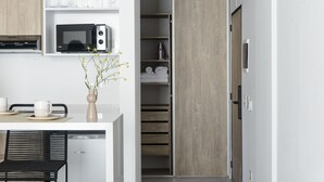 Uma cozinha moderna com micro-ondas, cafeteira e um vaso com flores.