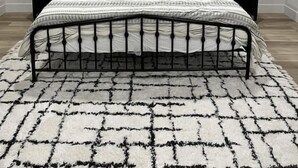 Ein Schlafzimmer mit einem Bett, zwei Nachttischen, einem runden Spiegel und einem Deckenventilator.