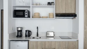 Une cuisine moderne équipée d’un four à micro-ondes, d’une machine à café, d’un grille-pain et d’un lave-vaisselle.