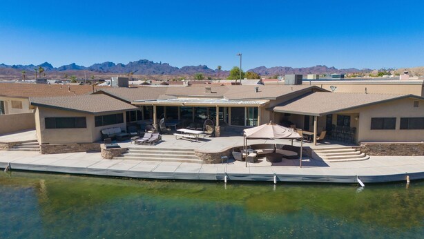A waterfront property with a covered patio area, outdoor seating, and a pool. - Dock Holiday – The Keys Favorite | Wild West River Escape (Parker)
