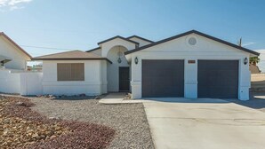 A residential property with a garage, a covered entryway, and a small attached structure. - Chippy, Saltwater Pool & Hot tub (Lake Havasu City)