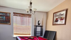 A pool table with a red felt surface, a black pool table, and a bench. - Cliff Hanger, River access with dock (Parker)